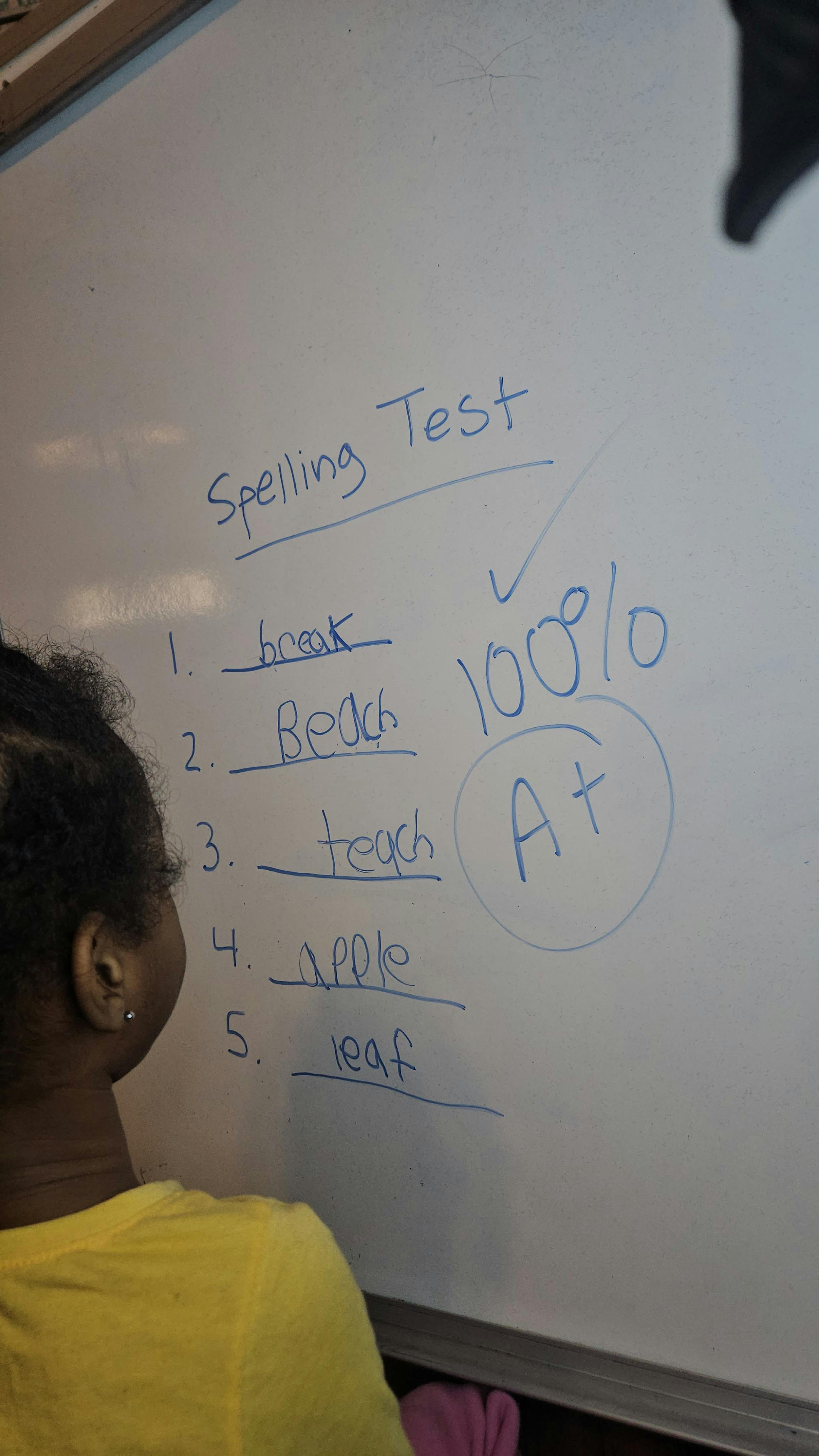 Close-up of a spelling test with a perfect score and A+ grade