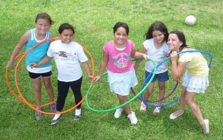 Five children playing with hula hoops outdoors