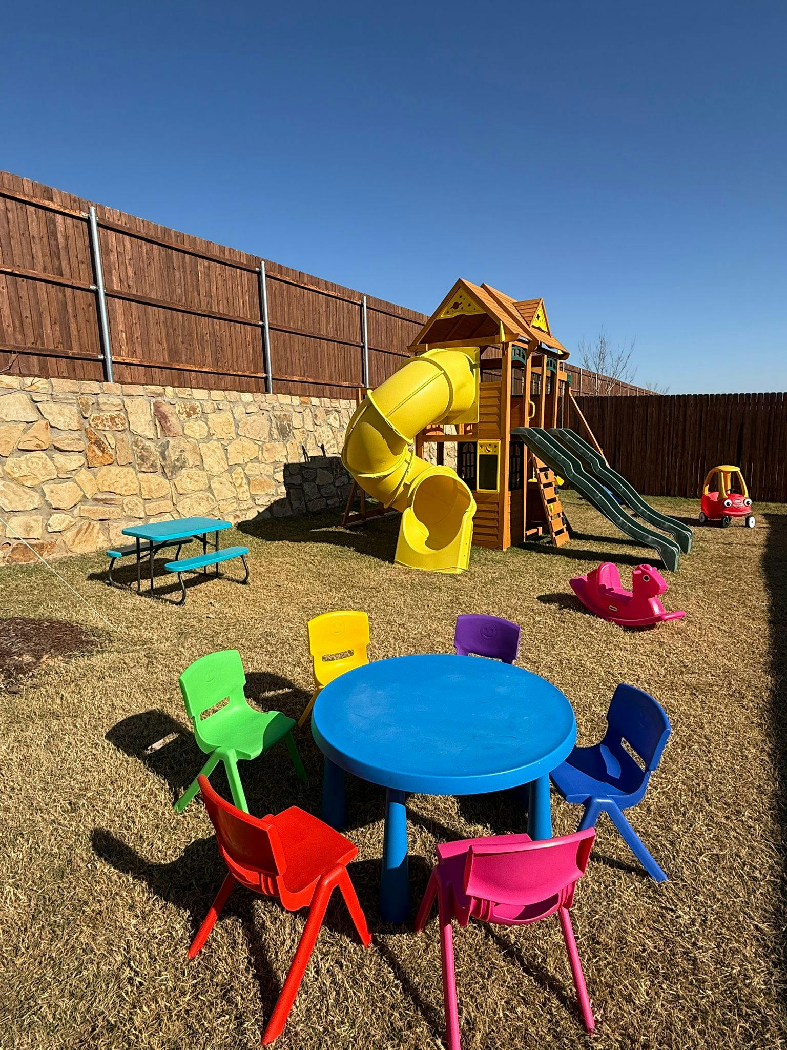 Playground with playset, slides, and colorful child-sized table and chairs