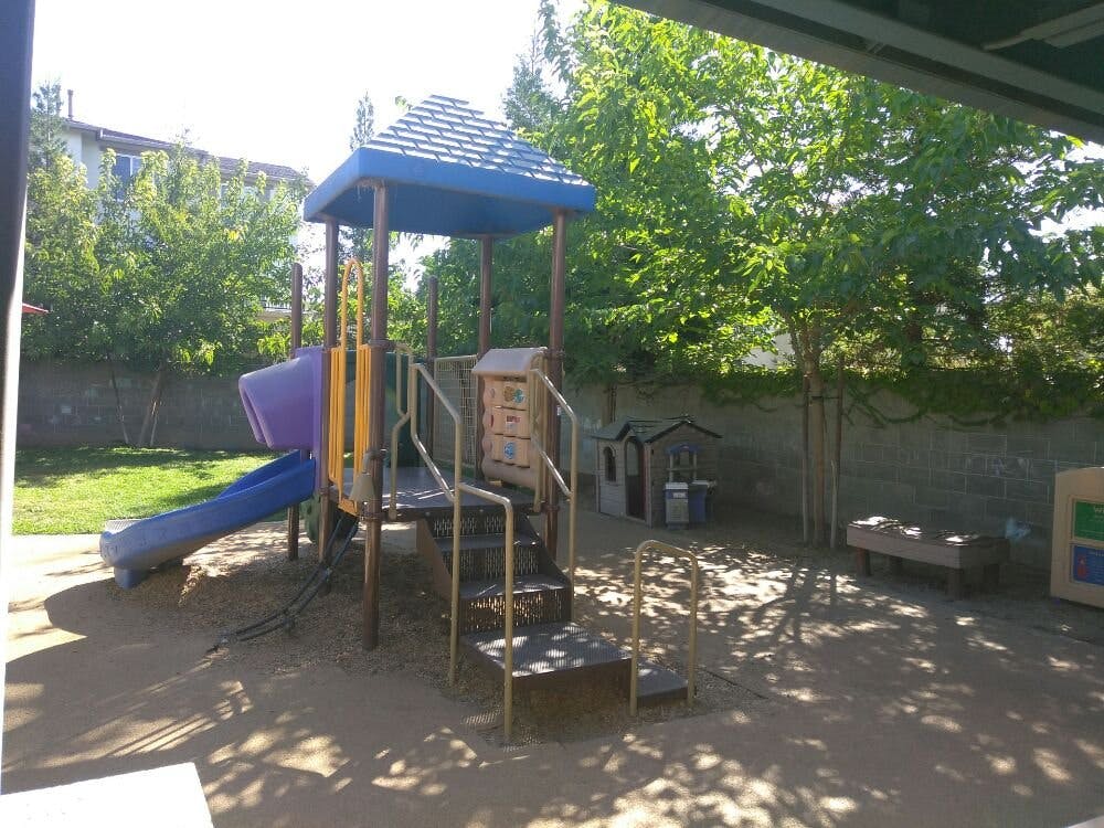 Playground with a slide, climbing structure, and small playhouses