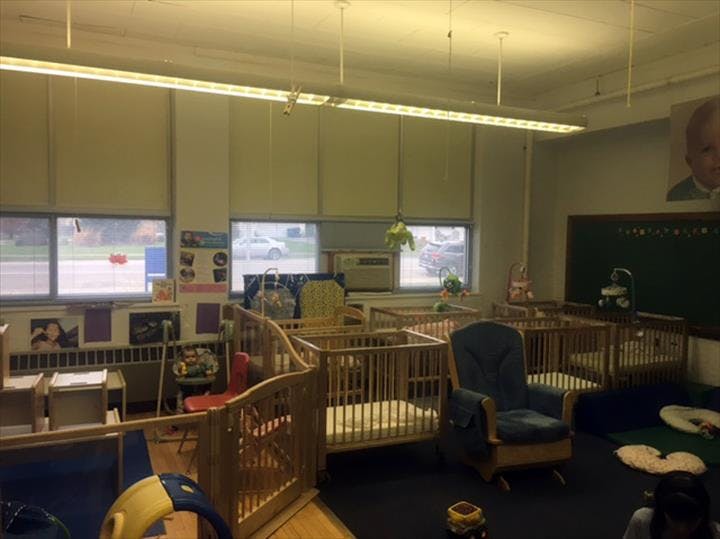 Nursery room with multiple cribs and a rocking chair