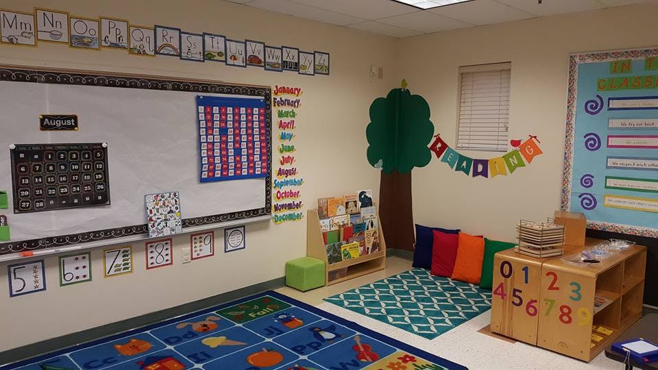 Classroom with a whiteboard, colorful rugs, and learning materials