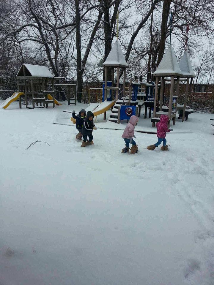 Children playing in snow on a playground
