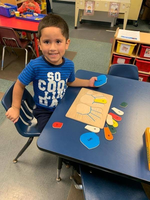 Child at a desk with a puzzle