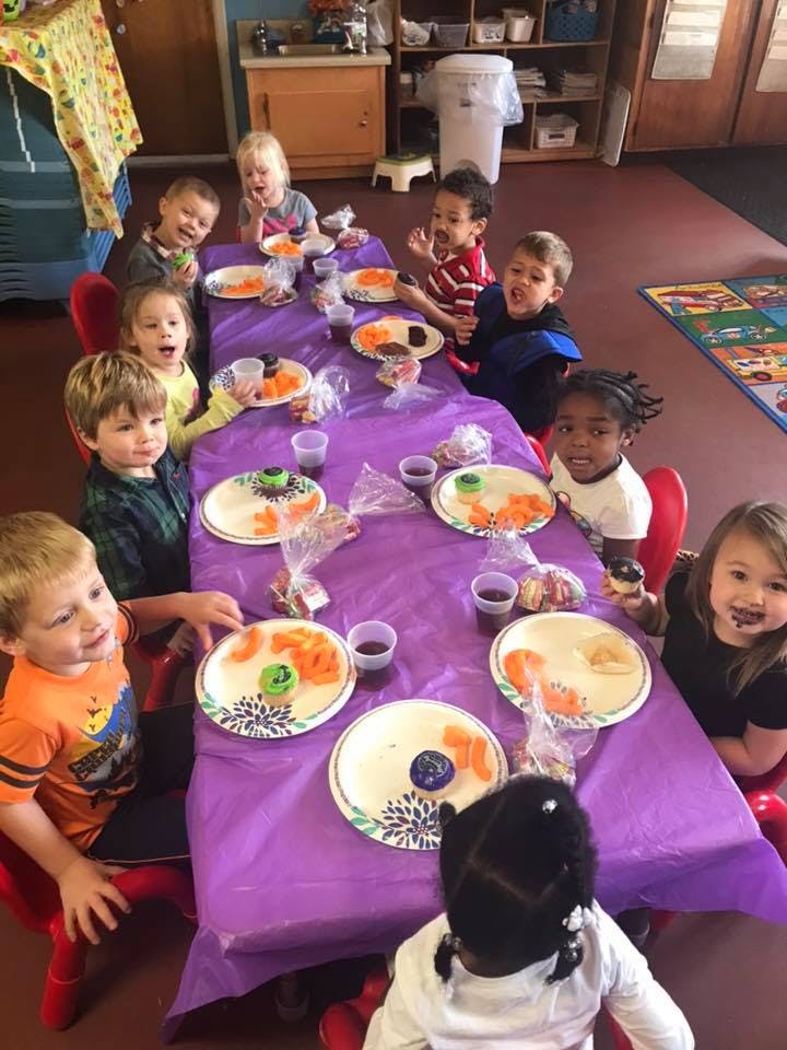Children sitting at a table with plates of food