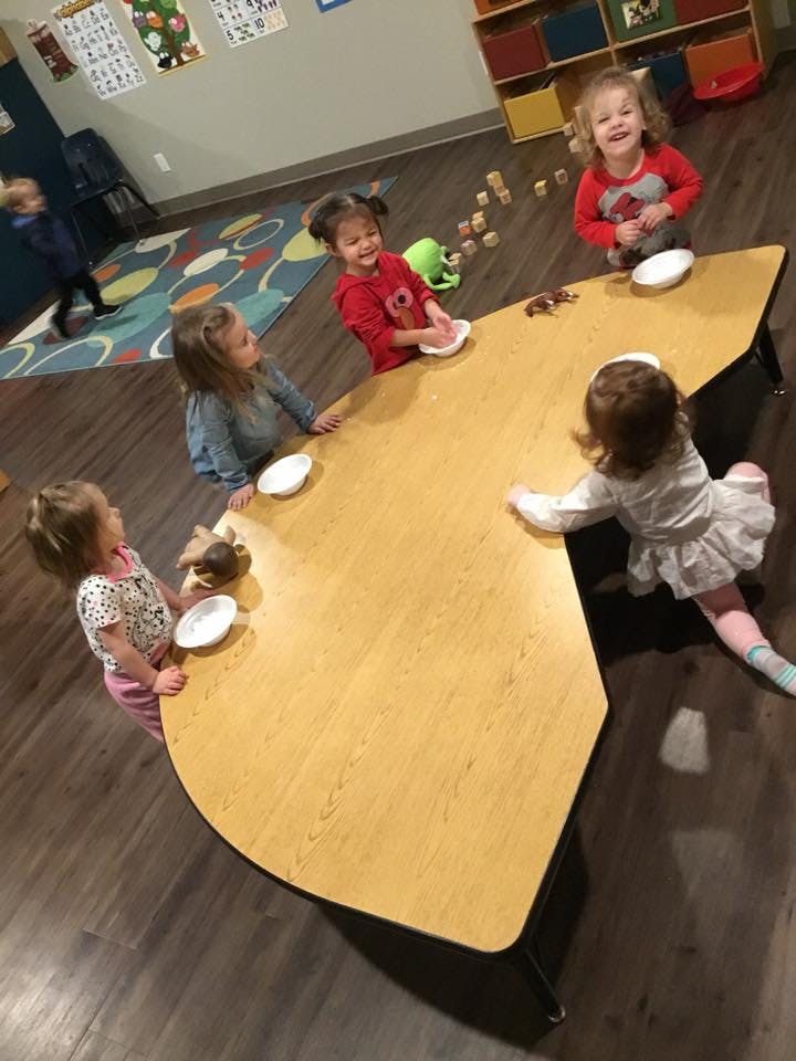 Children gathered around a table in a classroom