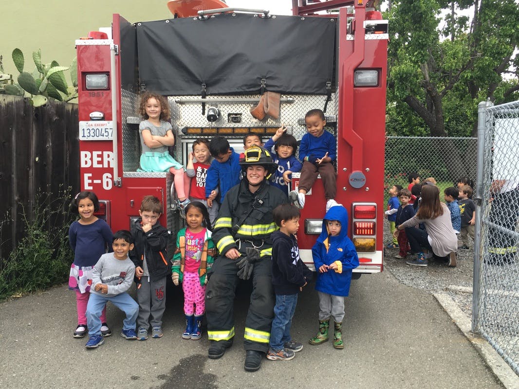 Firefighter posing with children on and around a fire truck