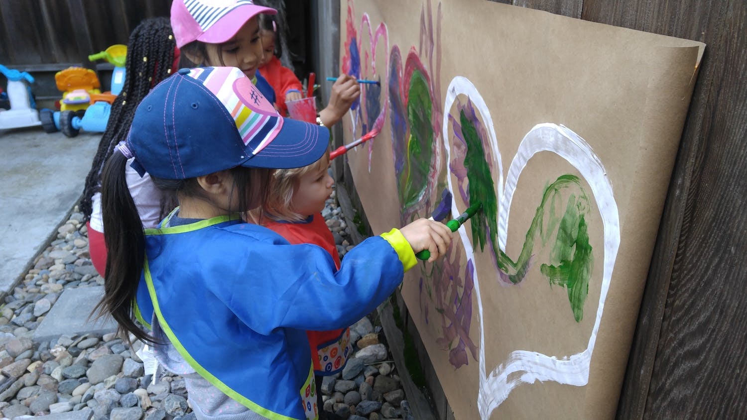 Children painting on a large sheet of paper