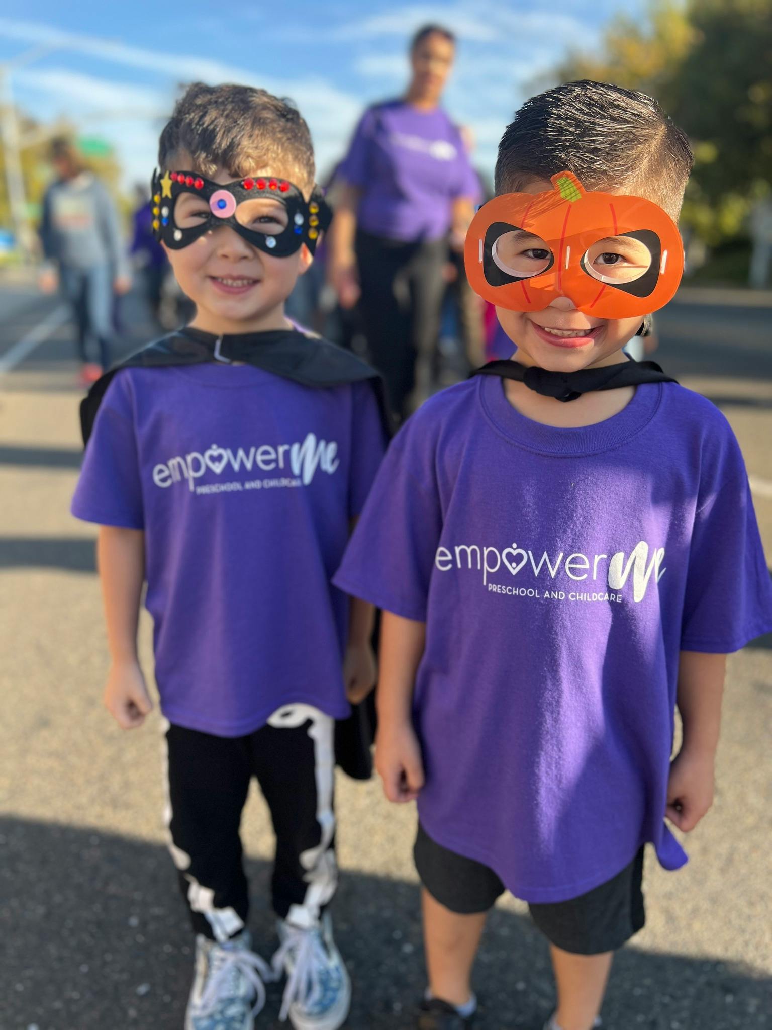 Two children wearing purple shirts and masks