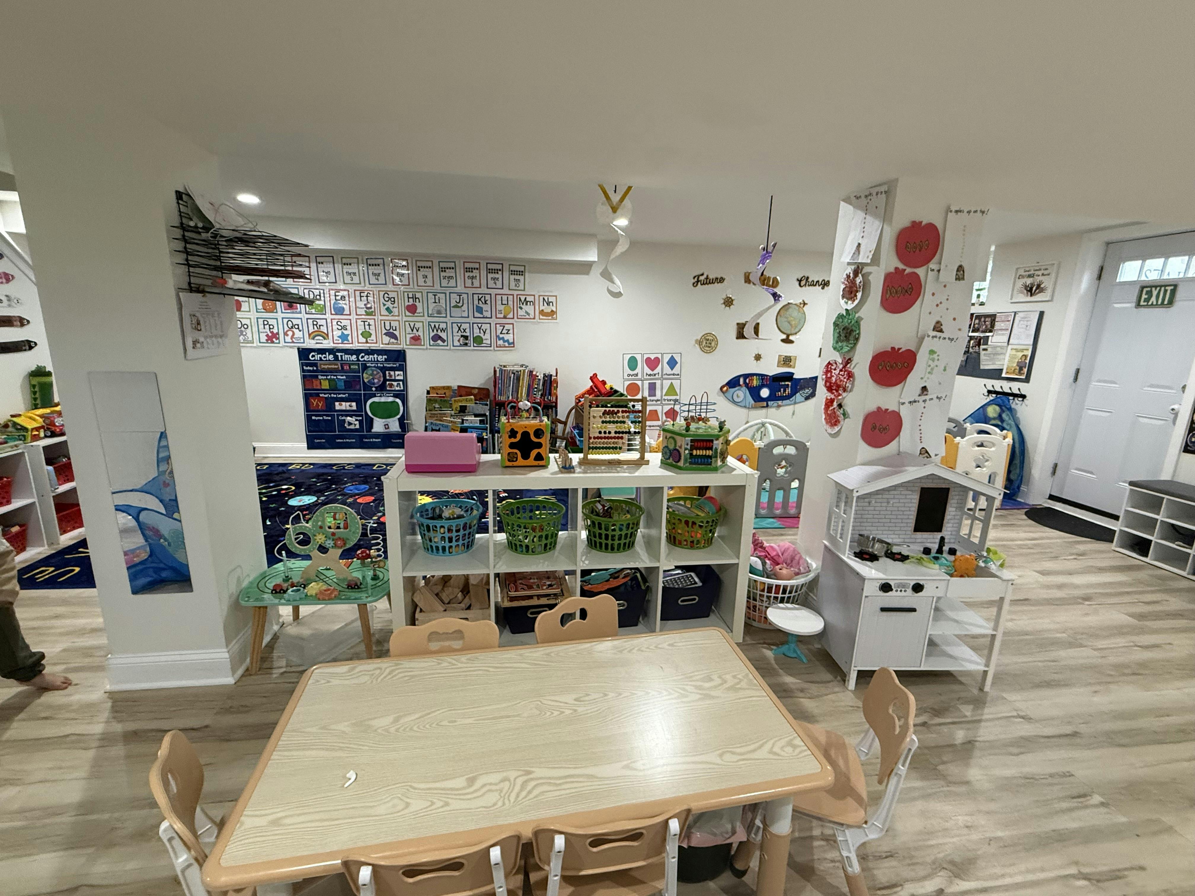 Classroom interior with educational toys, tables, and learning charts on walls
