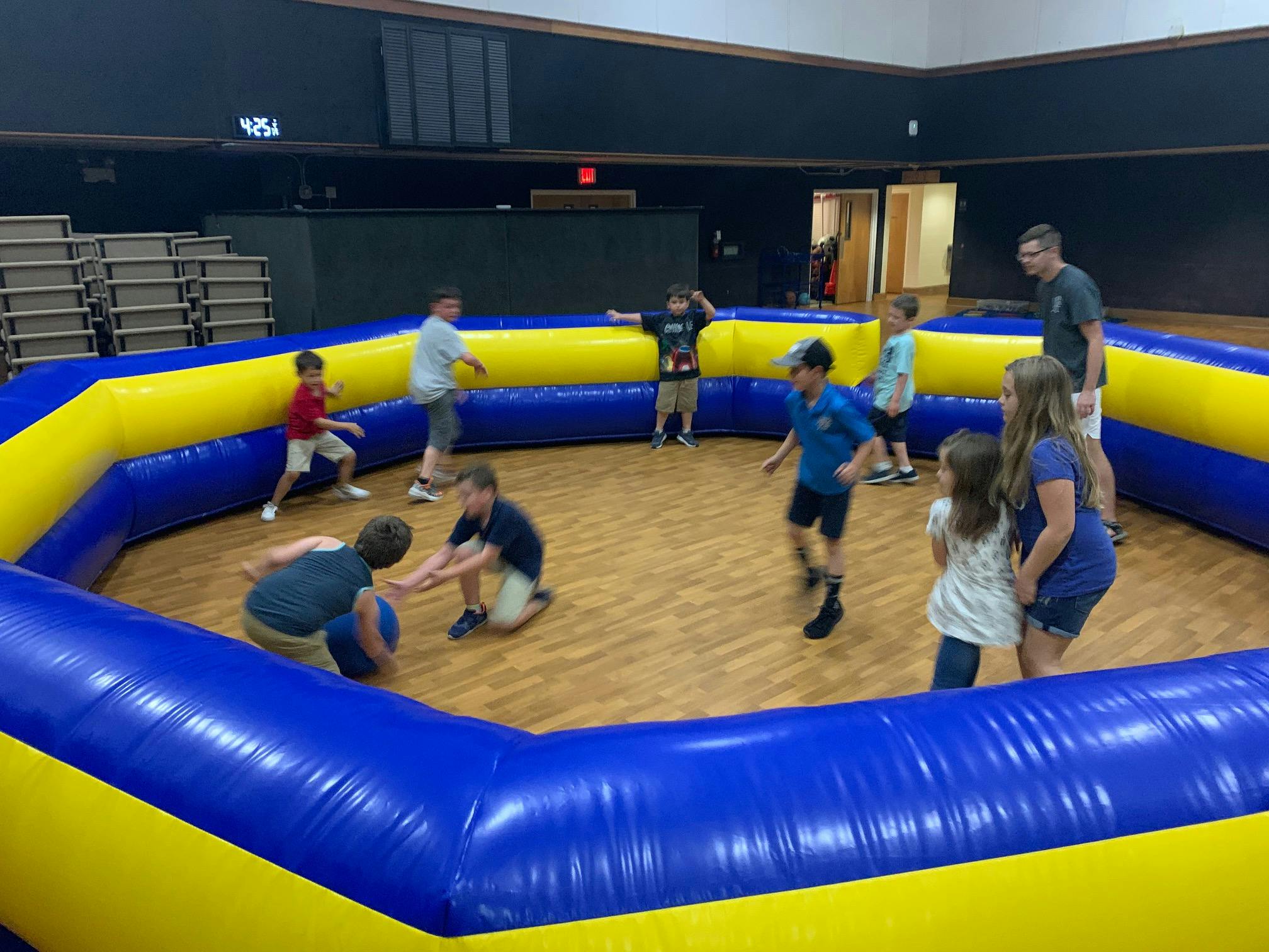 Children and adults playing in an inflatable arena