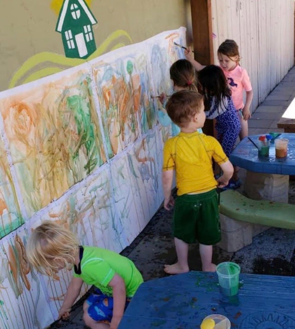 Children painting a mural outdoors