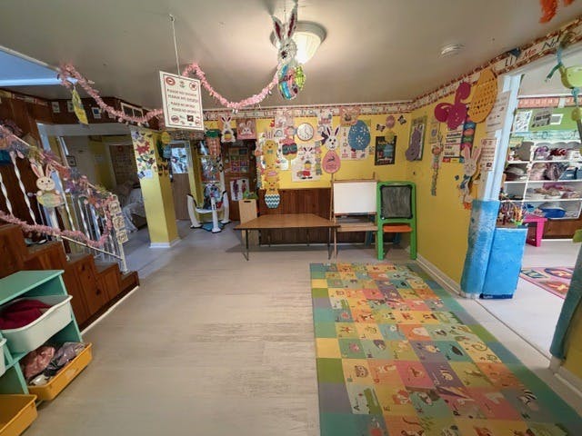 Playroom with bright yellow walls decorated with Easter bunnies and a colorful alphabet rug