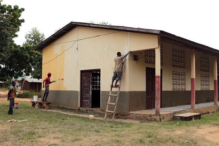 People painting the exterior wall of a building