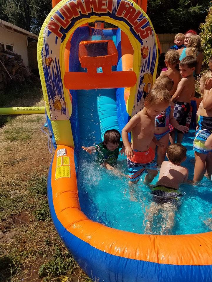 Children playing in an inflatable water slide and pool