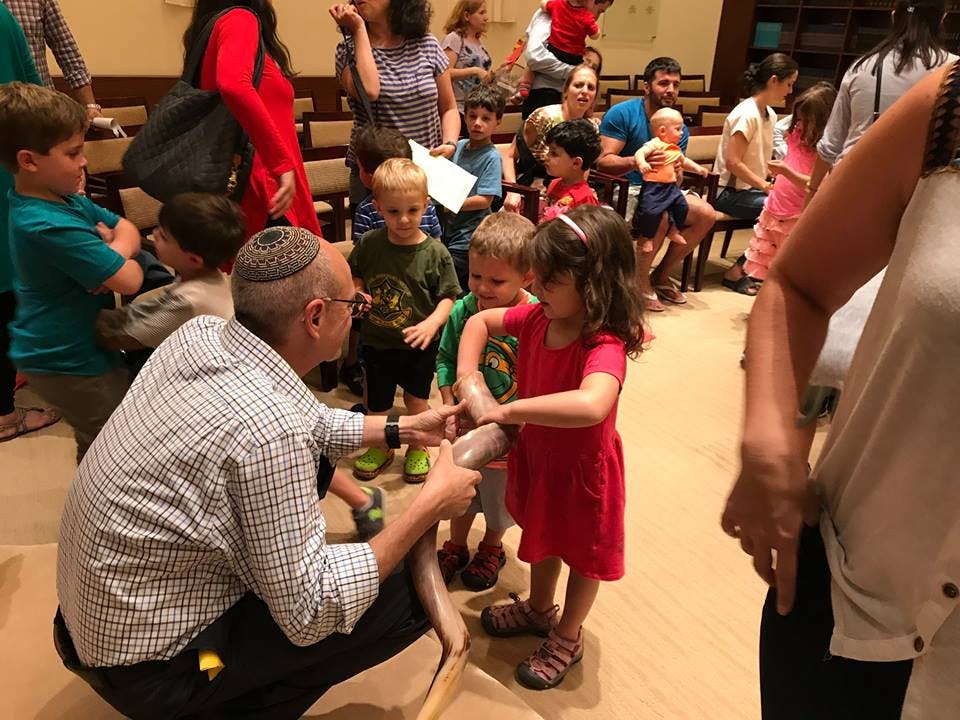 Adult in yarmulke interacting with children
