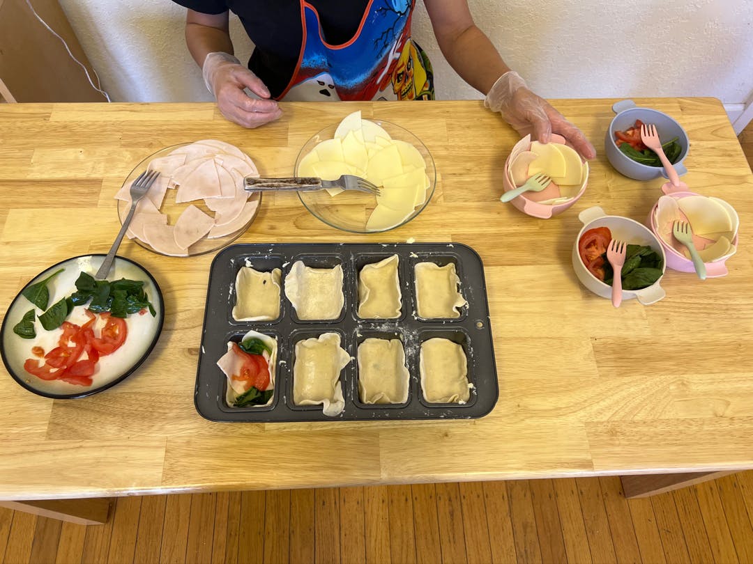 Person preparing food with ingredients on a wooden table