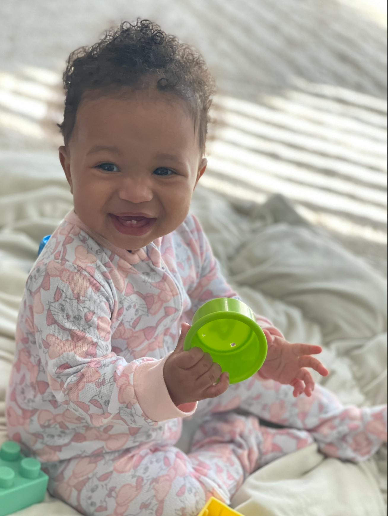 Child playing with a green toy cup