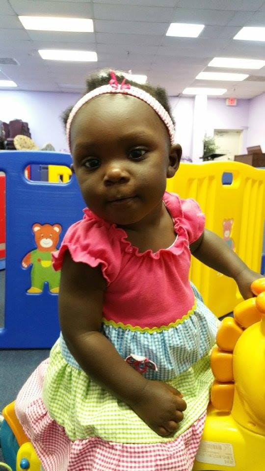 Child in a pink shirt and colorful checkered skirt