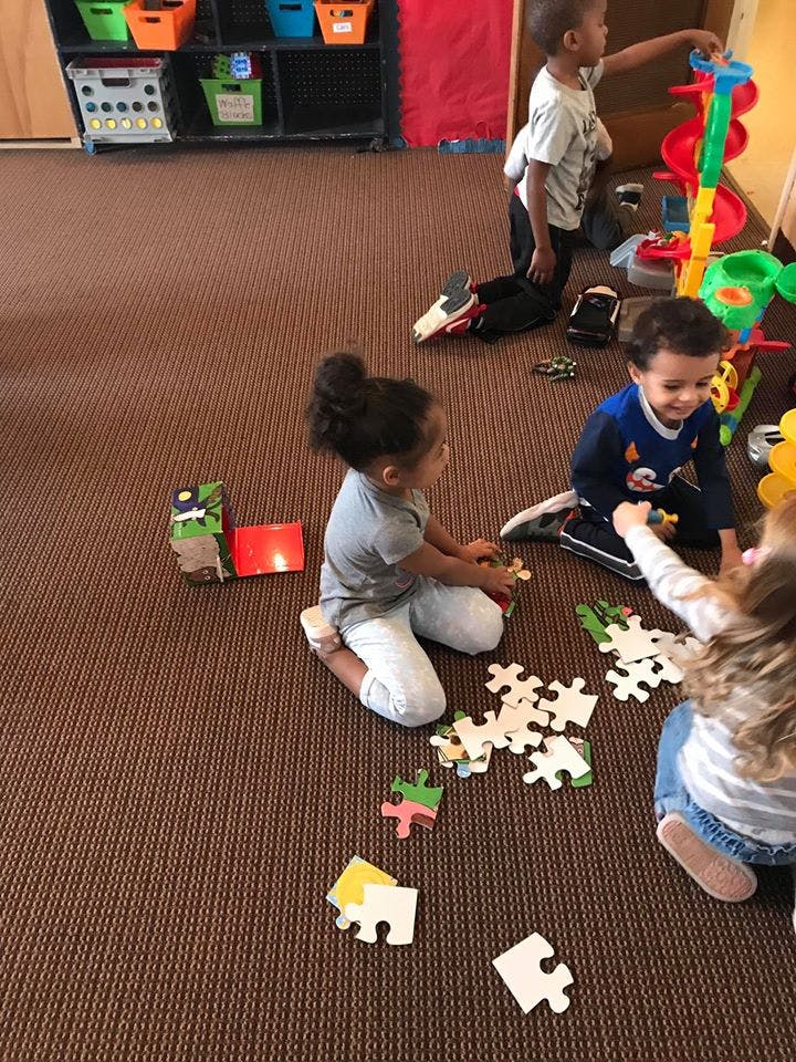 Children playing with puzzles and toys on the floor