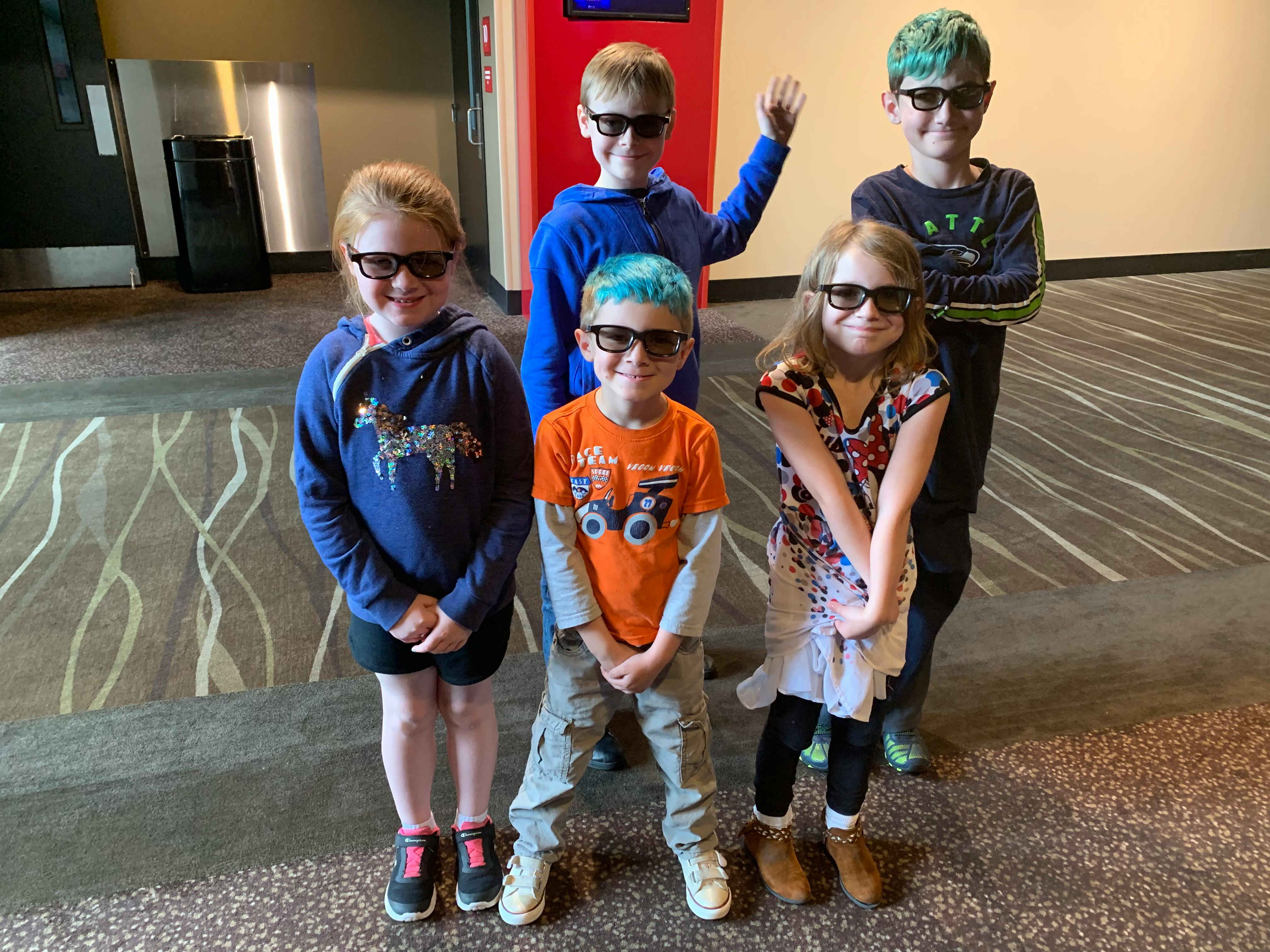 Five children wearing 3D glasses standing together
