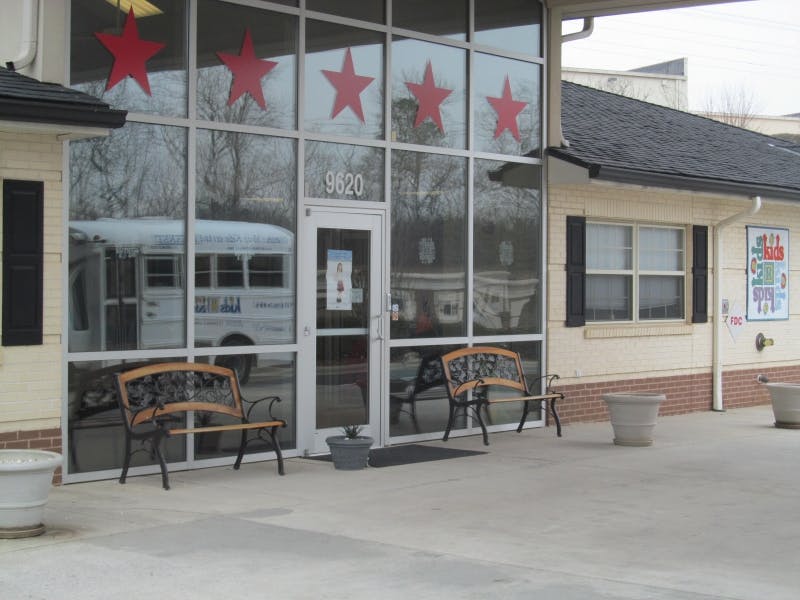 Building exterior with large windows decorated with red stars, benches outside