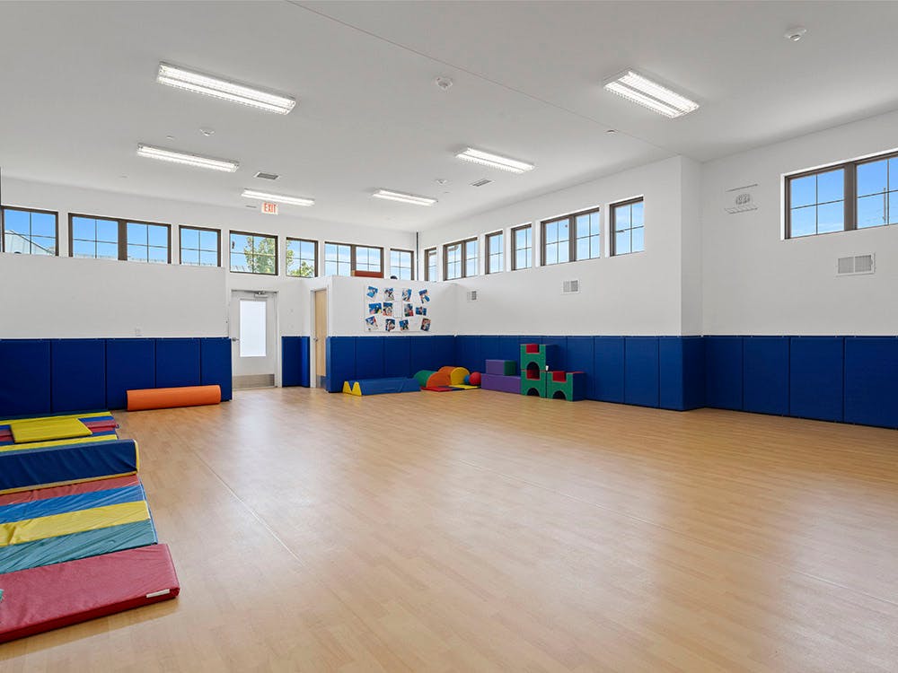 Empty classroom or playroom with blue padded walls and colorful mats