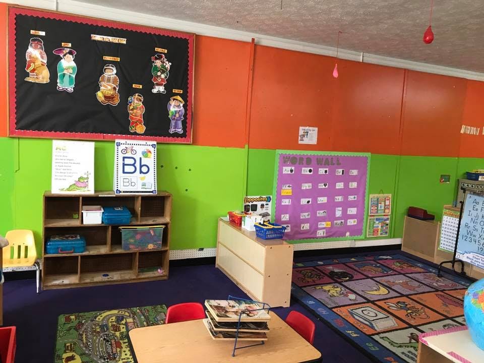 Colorful classroom with bulletin boards, shelves, and rugs