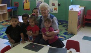 Adult and five children in a classroom