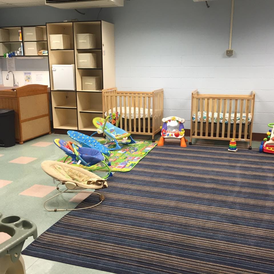 Two cribs and baby play items in a room