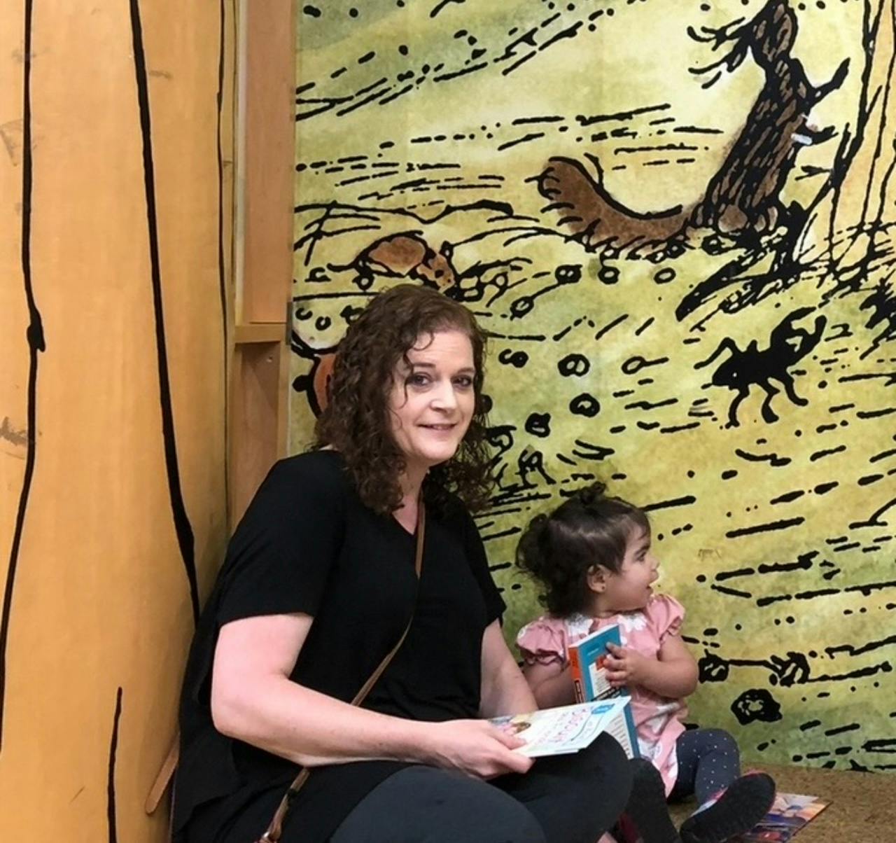 Person and child sitting with books