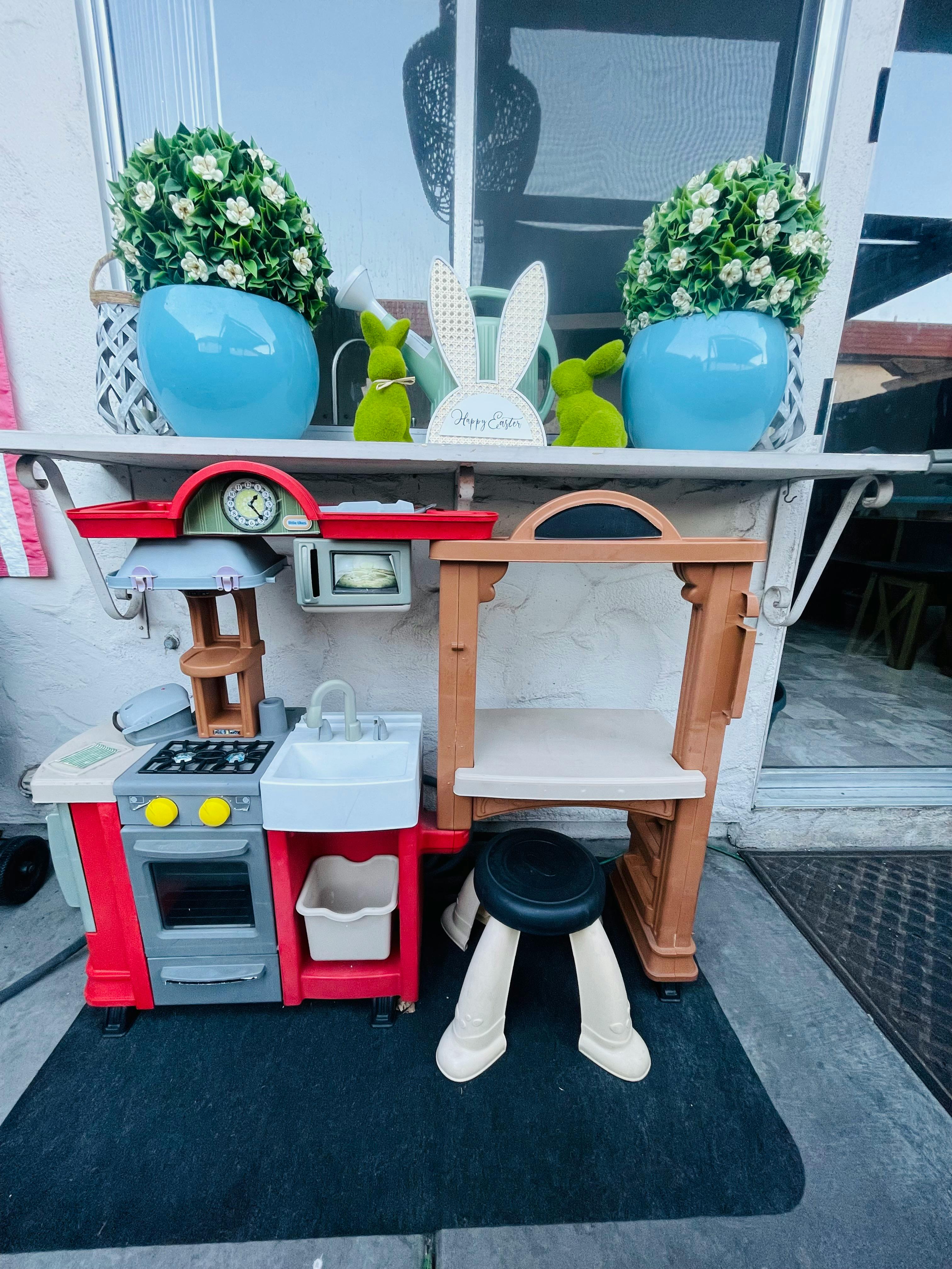 Toy kitchen set with a stove, sink, and a small stool