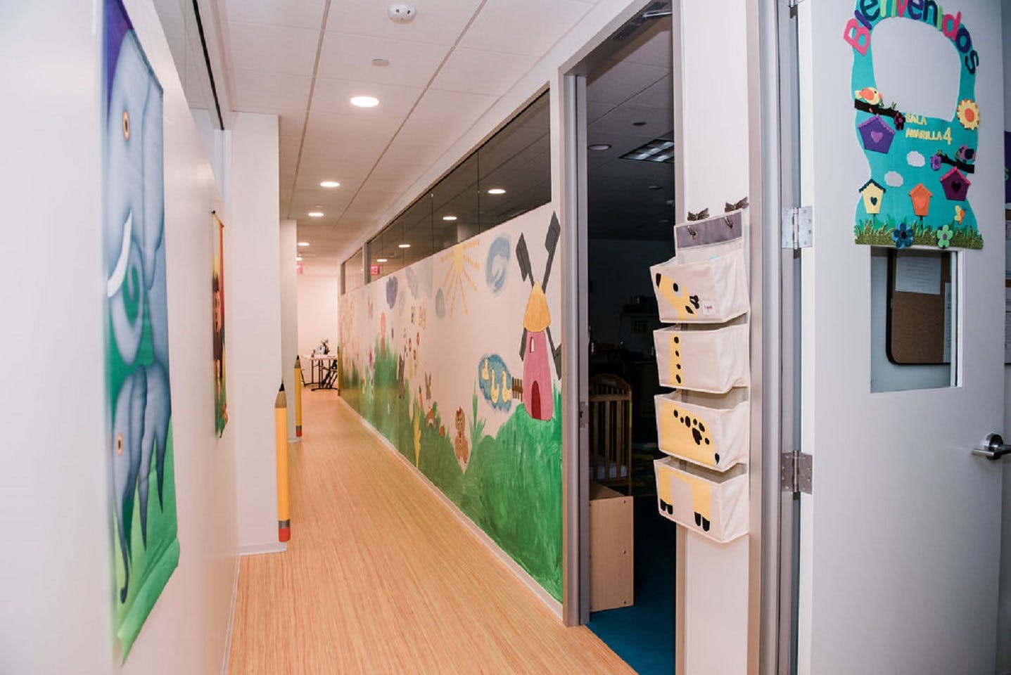 Hallway in a children's learning center with whimsical wall art and open doors