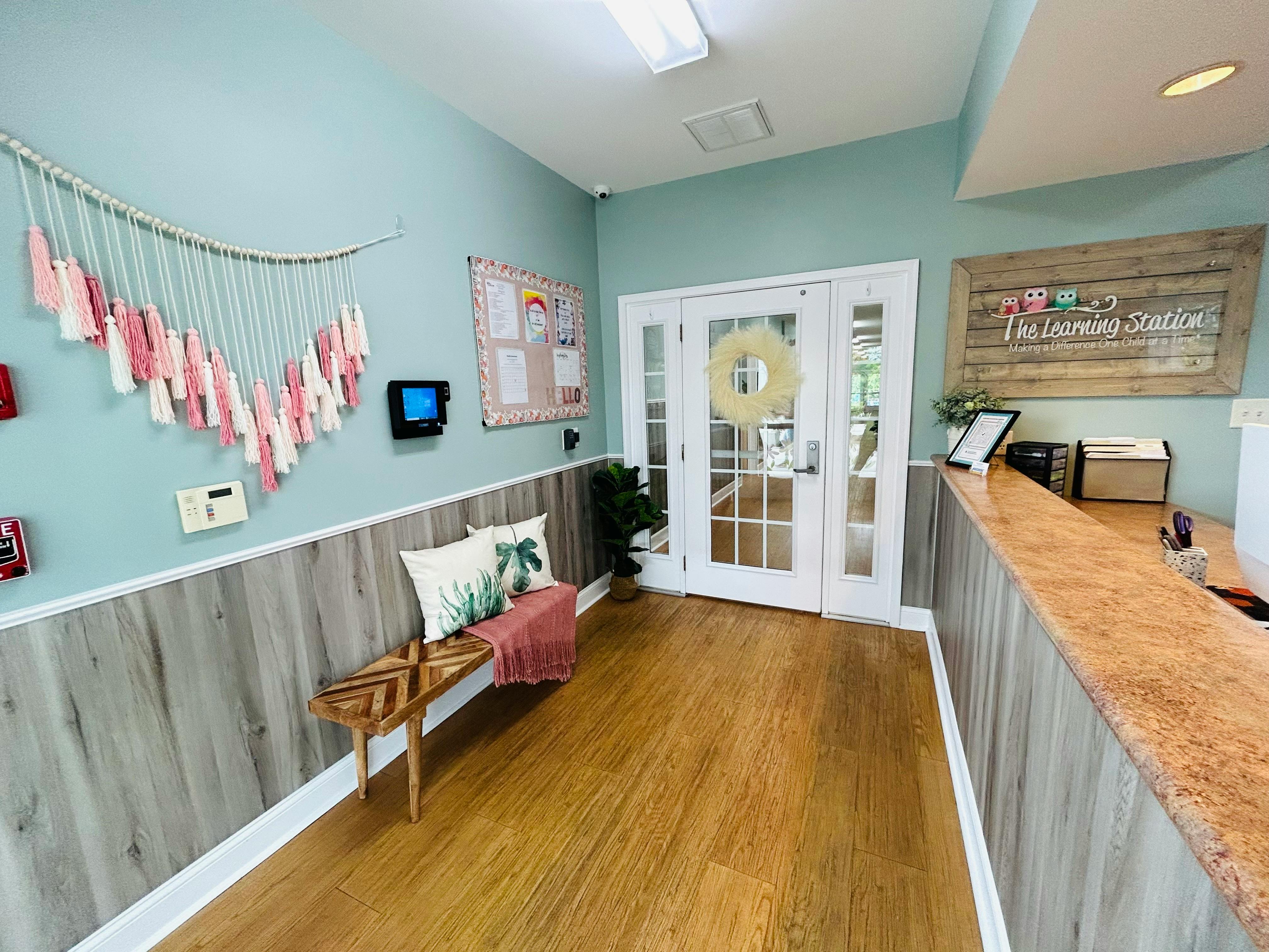 Reception area with a counter, bench, and double doors