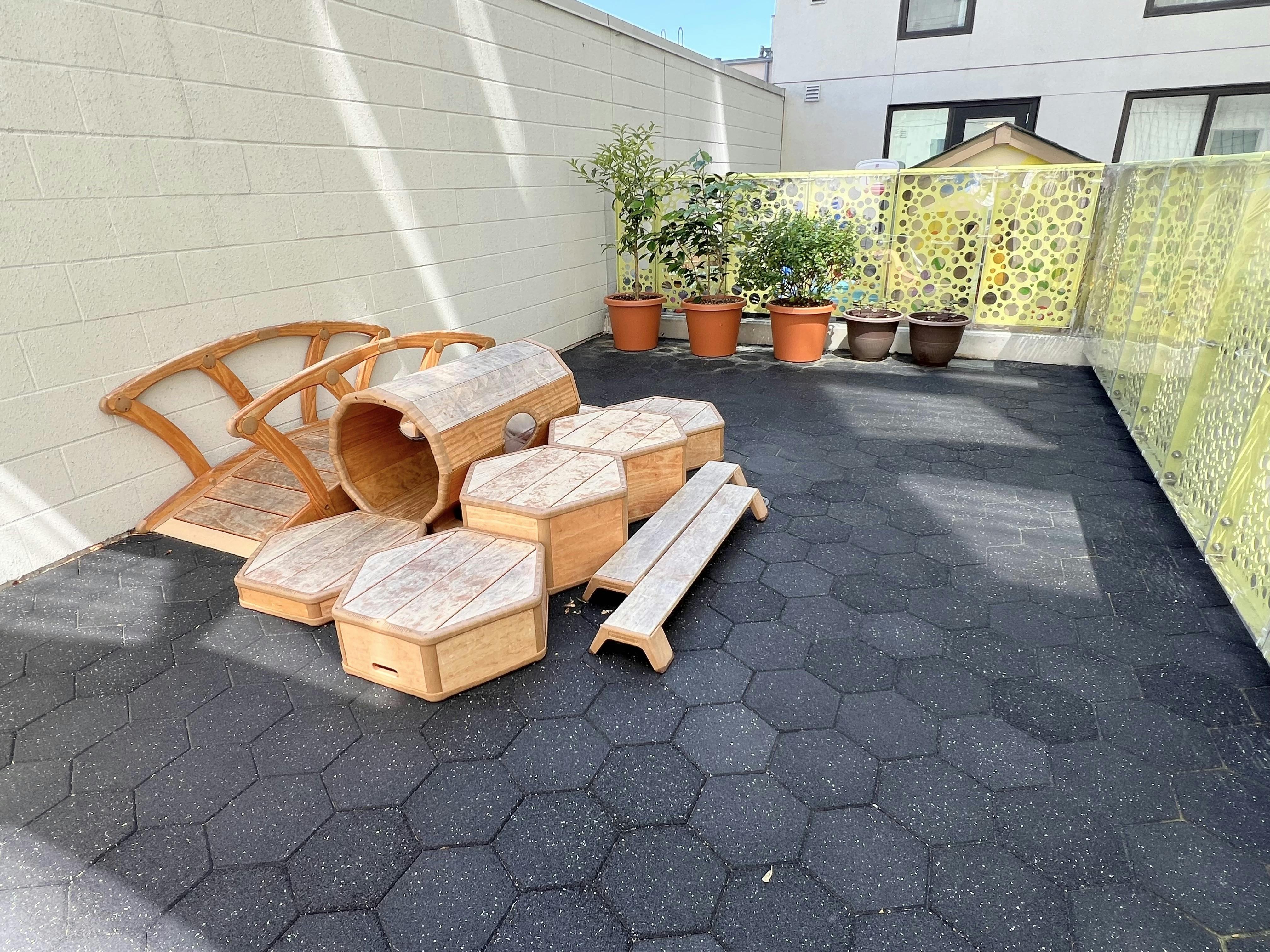 Wooden climbing structures and tunnel on a playground patio