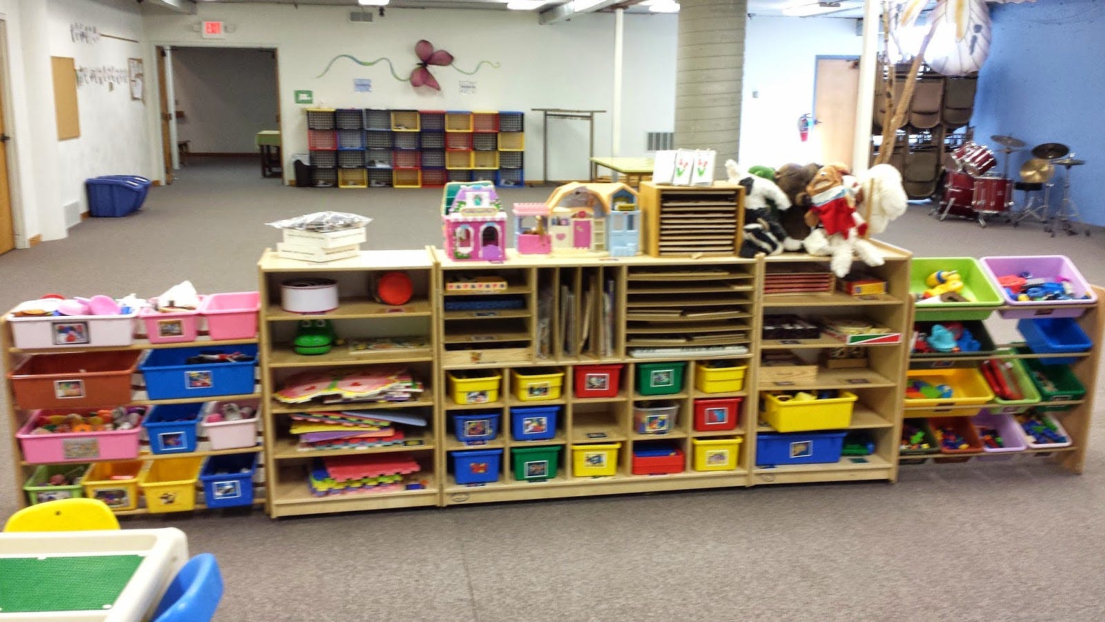 Shelving units with colorful bins and toys in a room