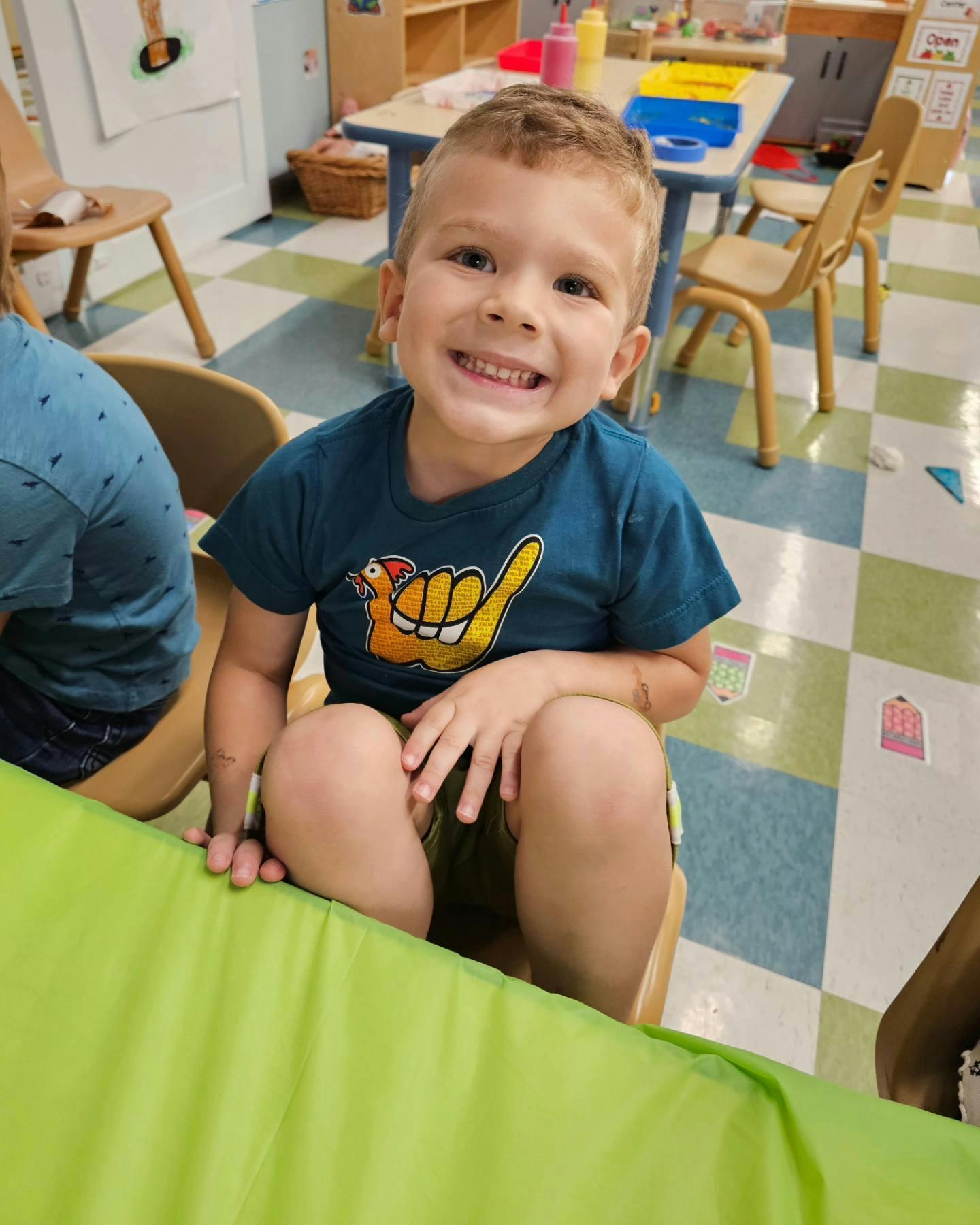 Child sitting at a table in a classroom