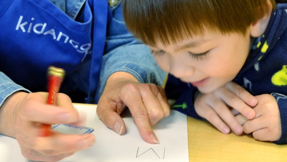 Adult and child writing on paper