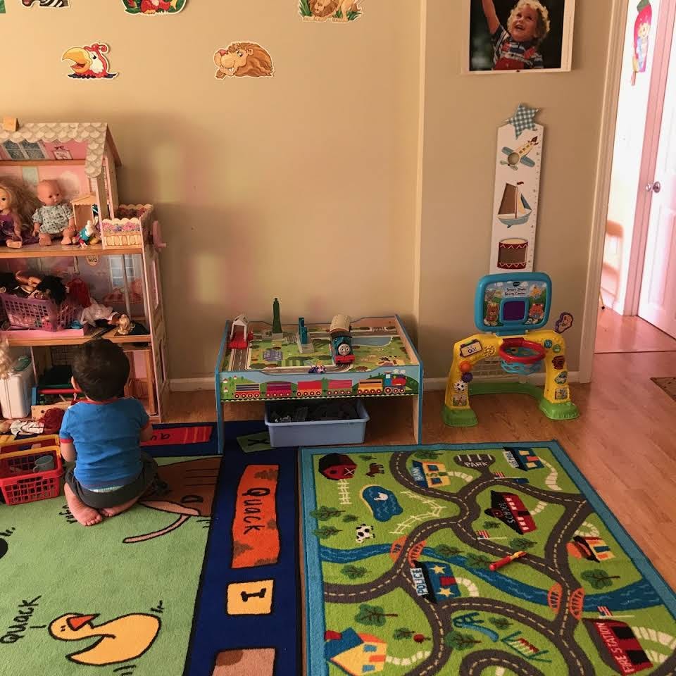 Child playing on the floor in a room with toys and playmats