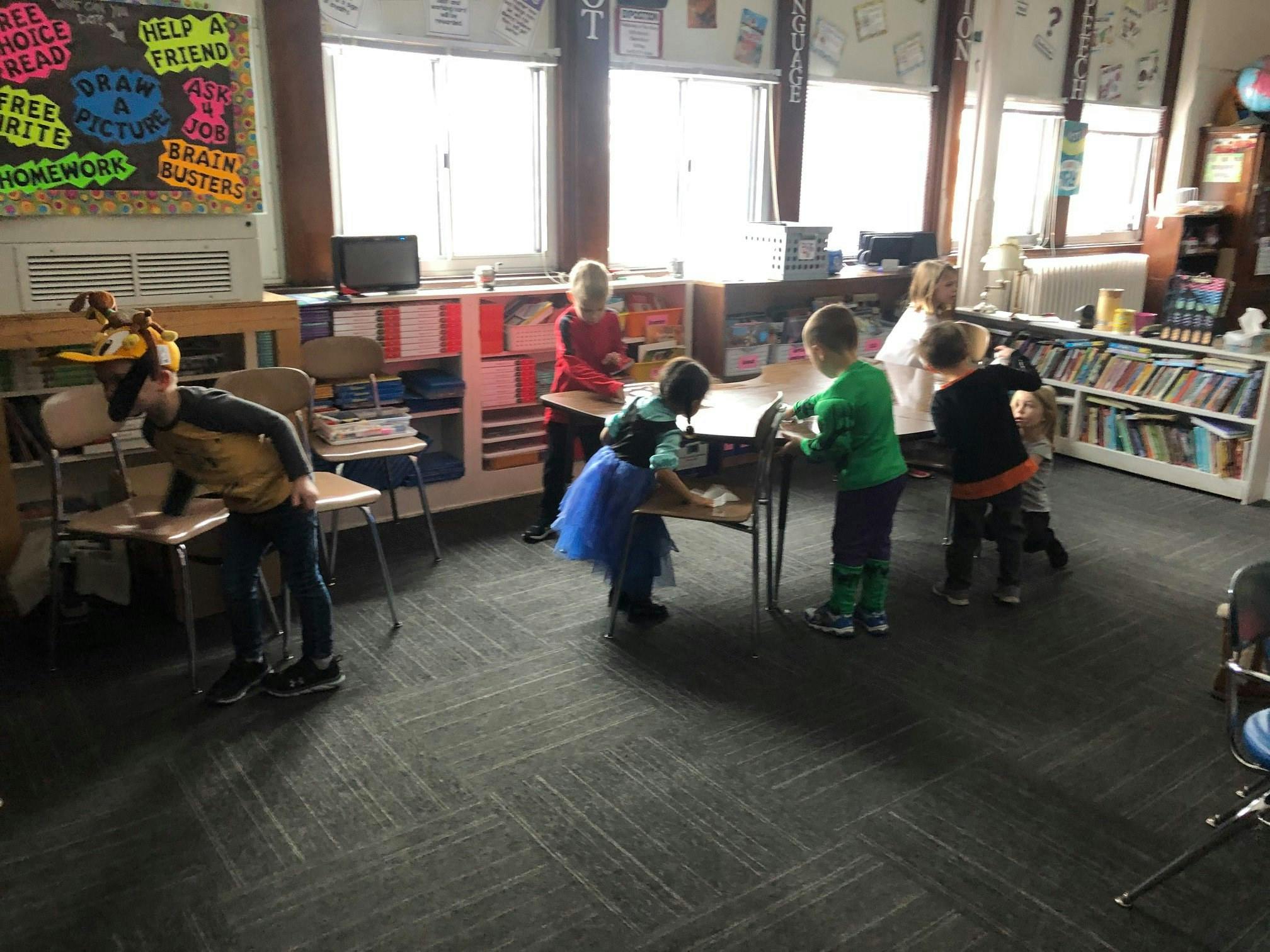 Children playing around a table in a classroom