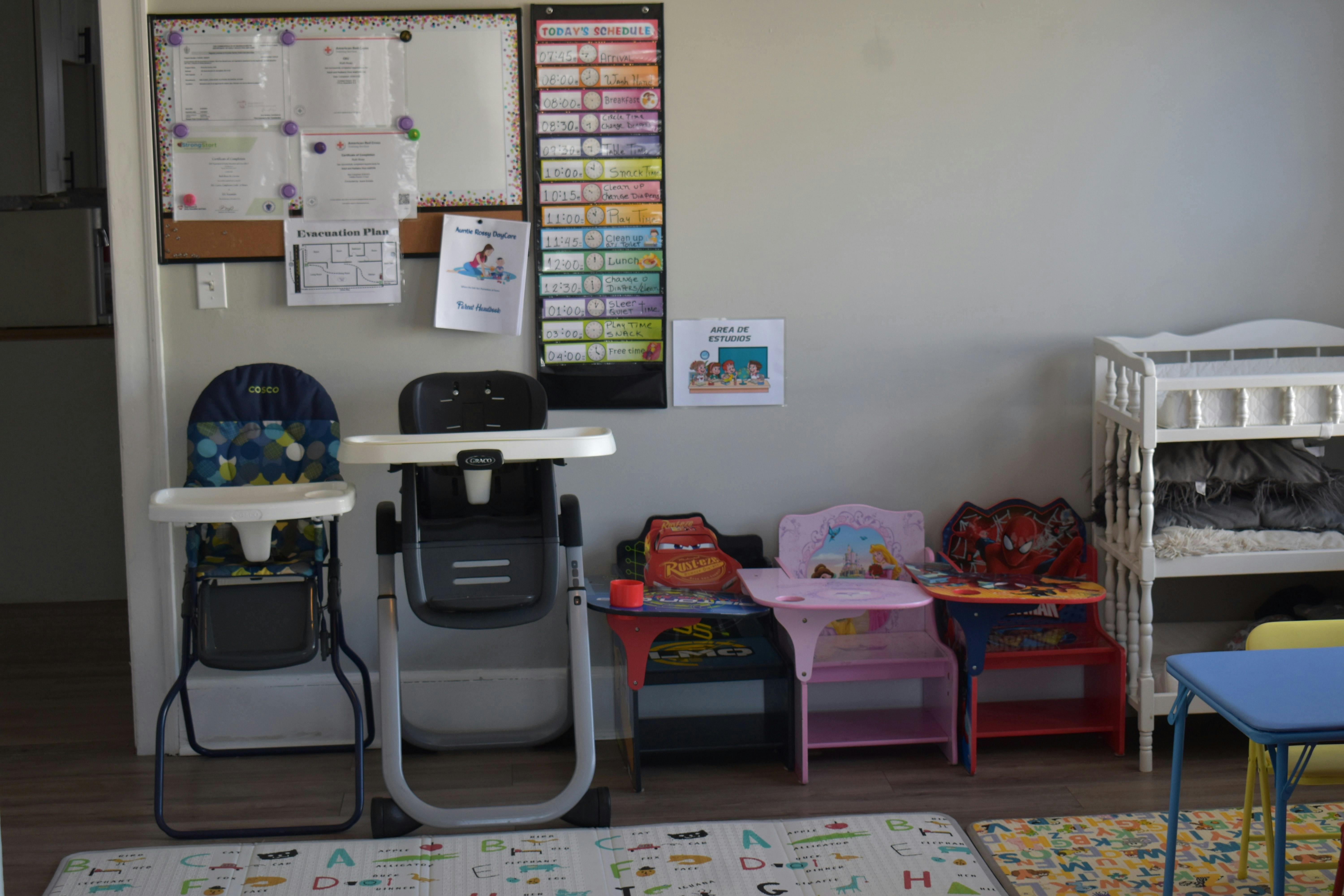 Two high chairs and small tables in a room with a bulletin board