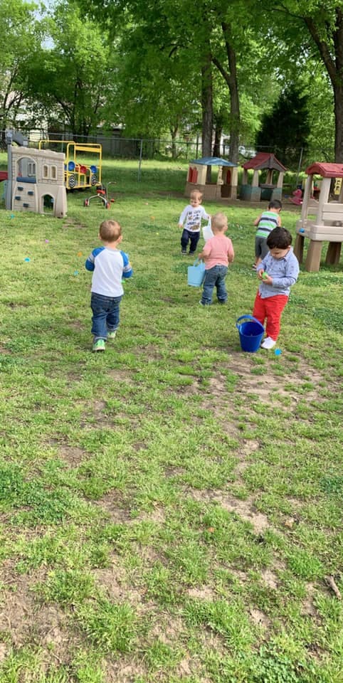 Children playing outdoors with buckets