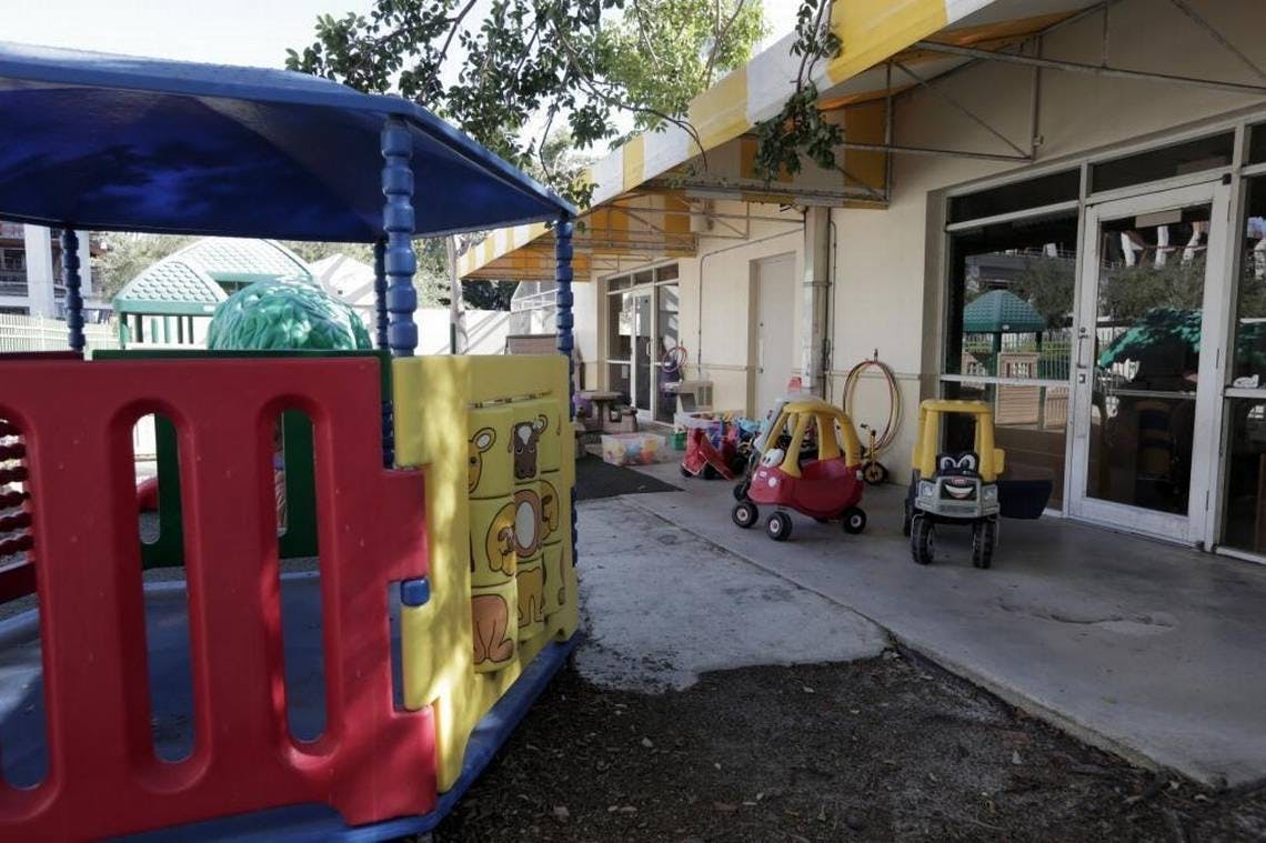 Playground equipment and toy cars outside a building