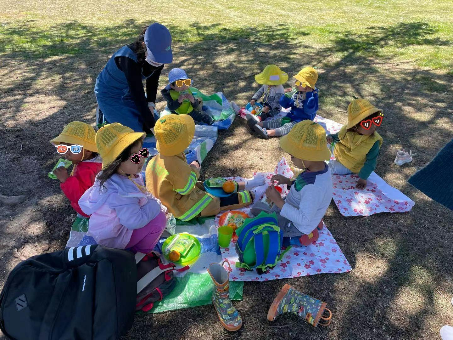 Adult and children sitting on blankets outdoors