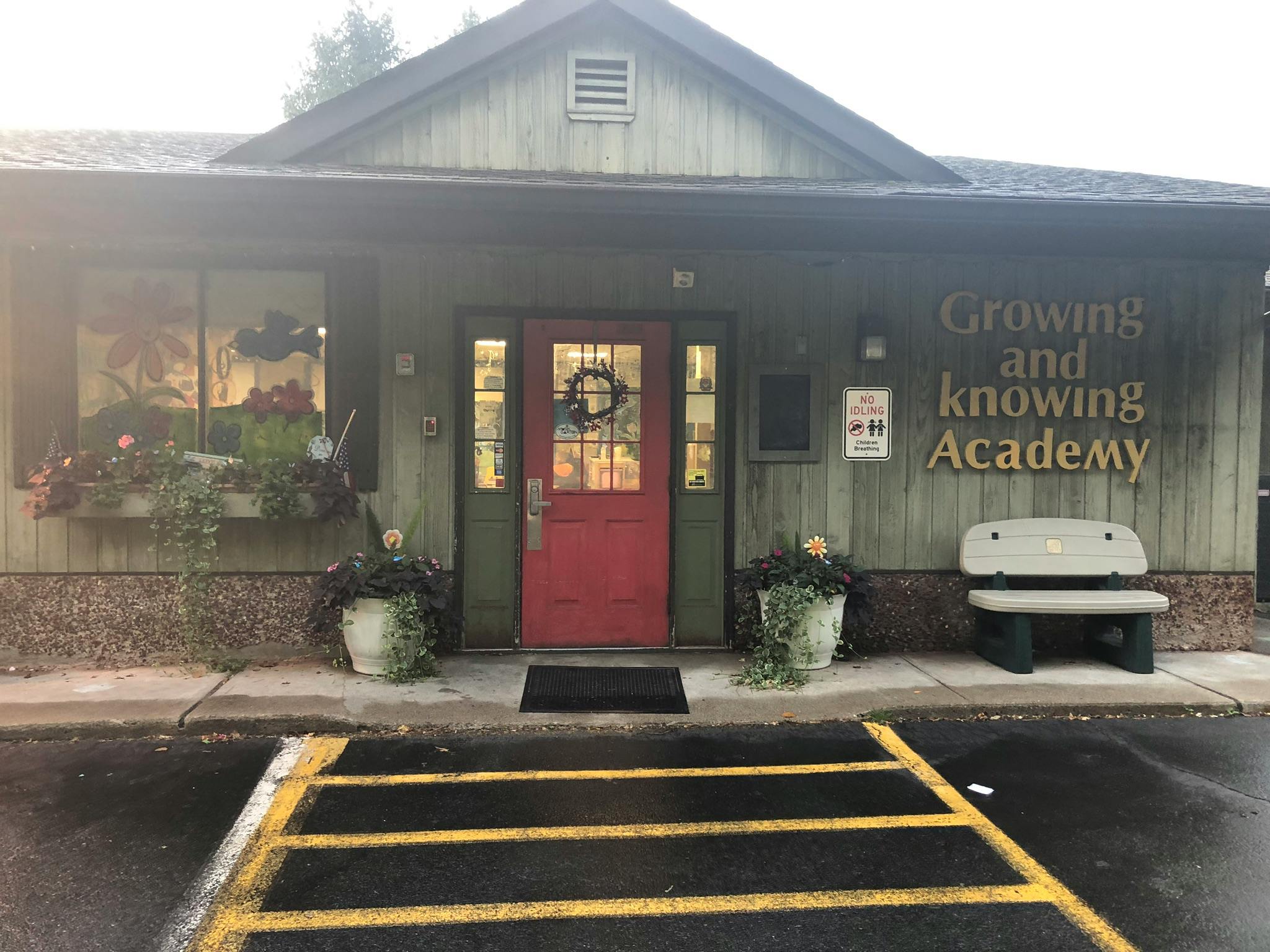 Building exterior with a red door and "Growing and Knowing Academy" sign