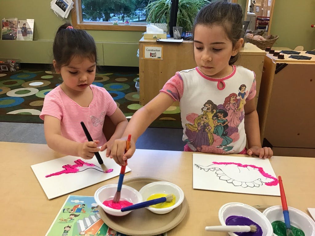 Two children painting at a table