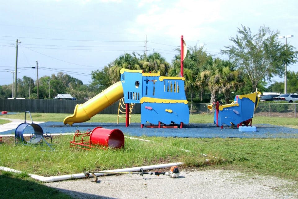 Playground with blue and yellow play structure and yellow slide