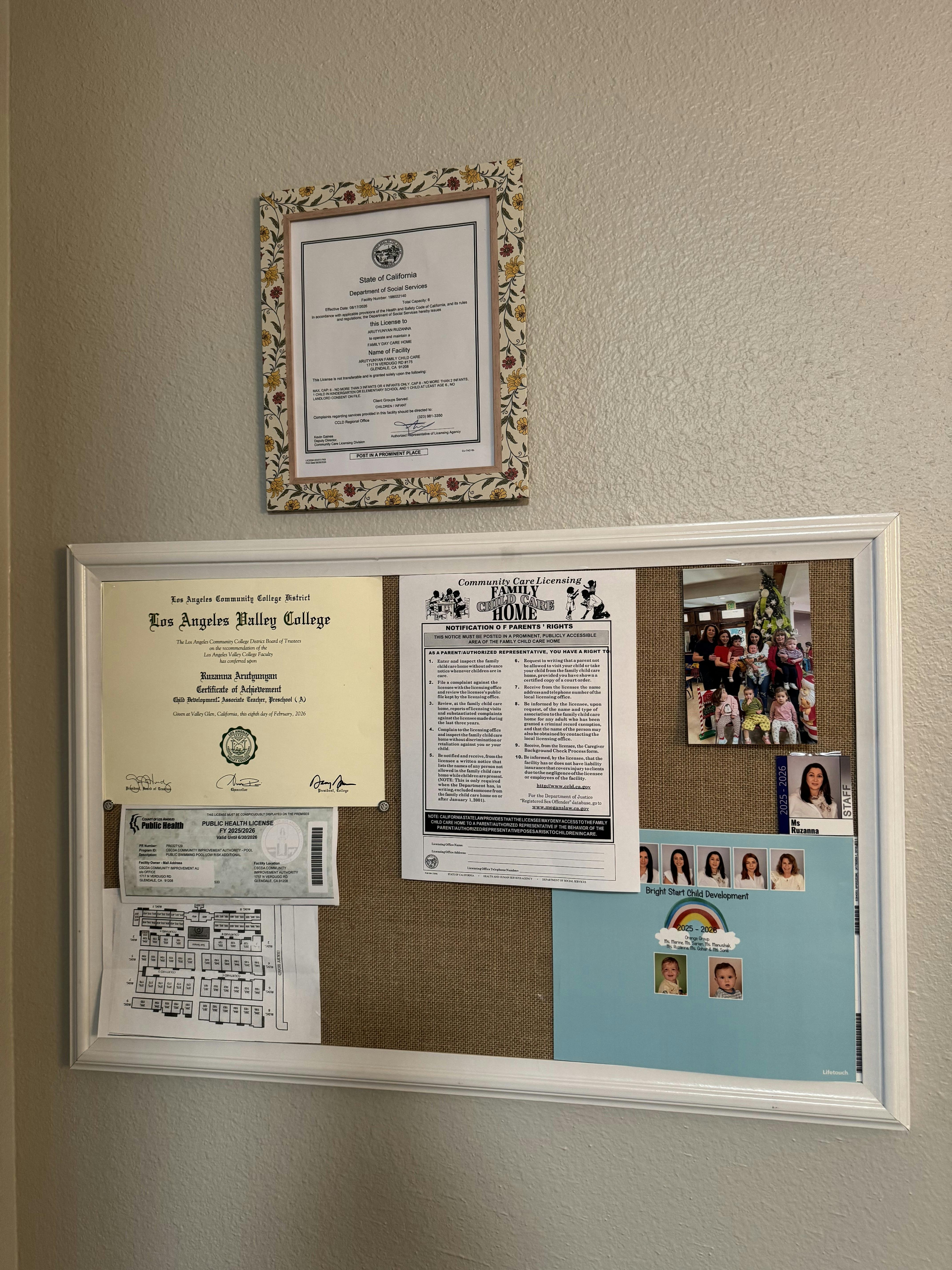 Child care facility license and documents displayed on a wall
