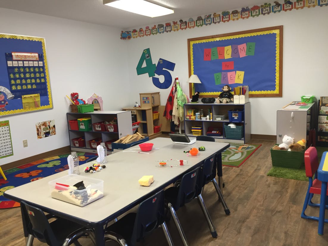 Classroom with tables, chairs, and bulletin boards
