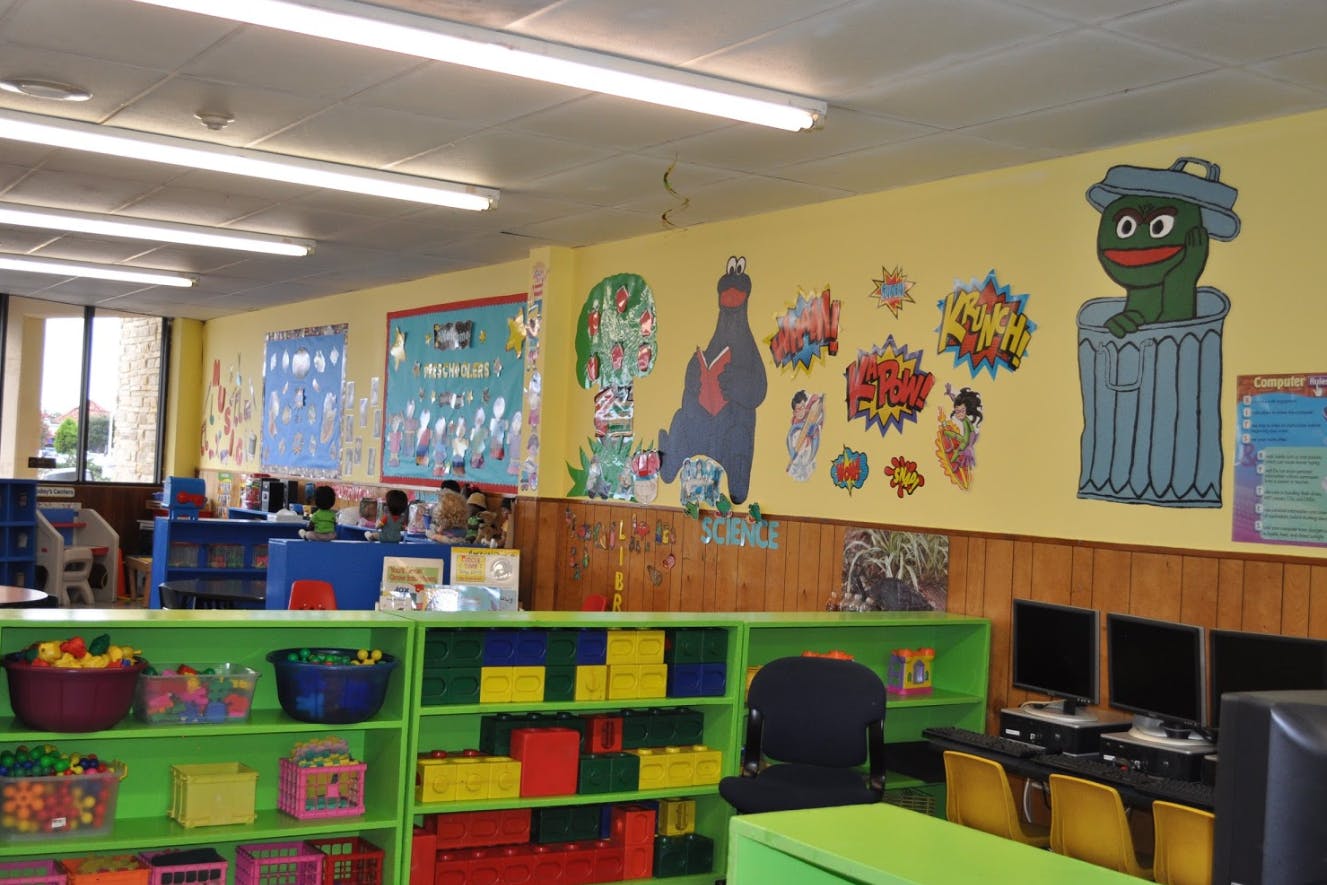 Classroom with colorful shelves, computers, and wall decorations